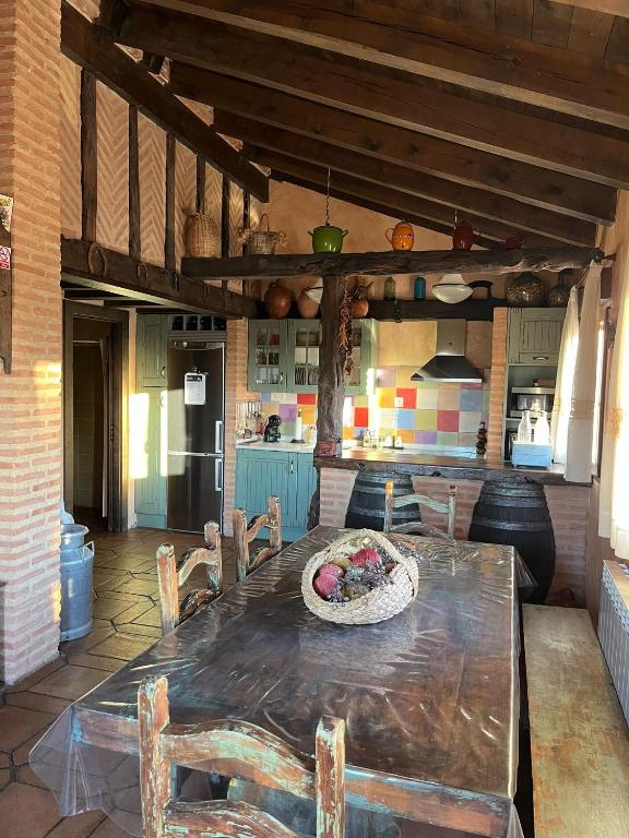 a kitchen with a table and chairs in a room at Casa Rural La Charolesa in Aguilera