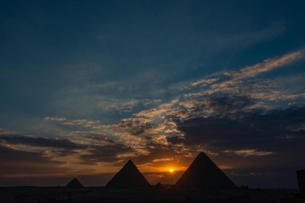 a sunset over the pyramids of the giza desert at Pyramids Acme Inn in Nazlet el-Sîsi