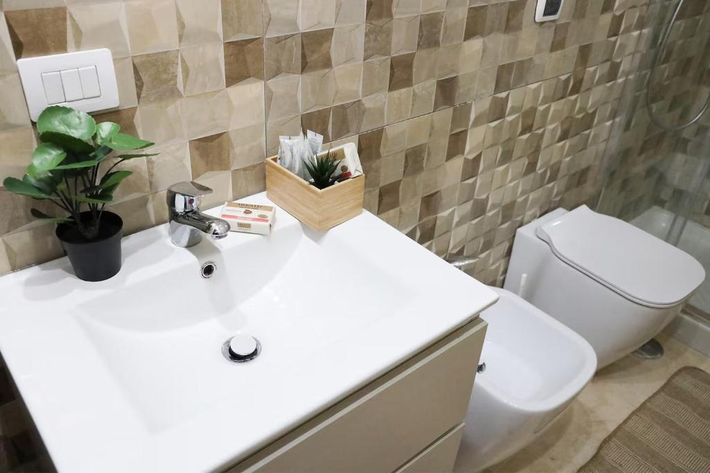 a bathroom with a white sink and a toilet at Country House, on the slopes of Vesuvius 3 in Terzigno