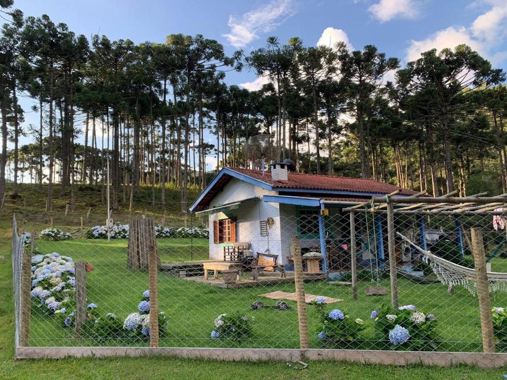 a small house behind a fence in a yard at Cantinho da Bubu in Gonçalves
