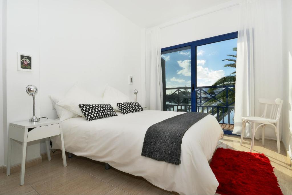 a white bedroom with a white bed and a window at Apartment La Raspa Sea Views 2 Bedrooms By PVL in Arrecife