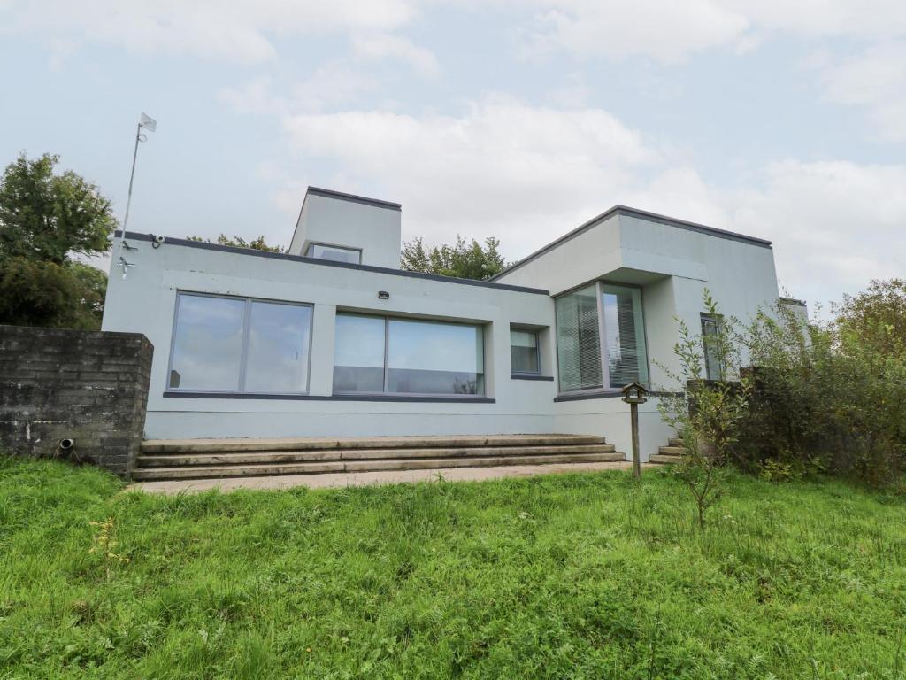 Casa blanca con ventanas de cristal y escaleras en Sruthan Lodge, en Cornamucklagh South