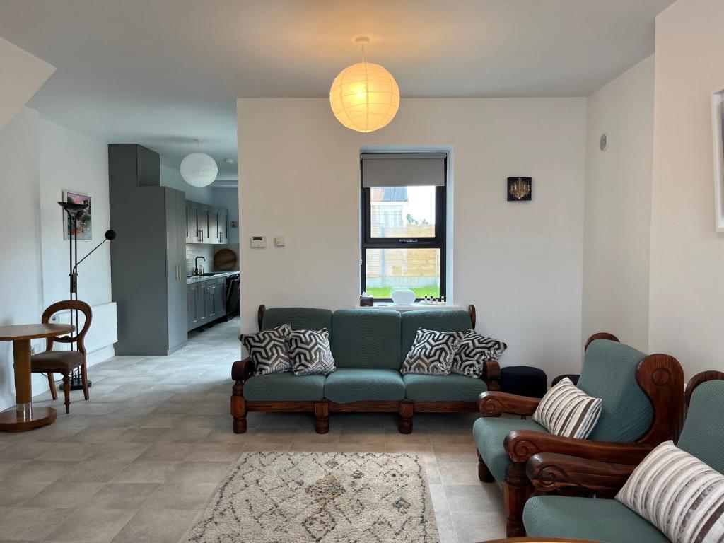 ein Wohnzimmer mit Sofa, Stühlen und einem Tisch in der Unterkunft Sunberry 2 Bright Modern Entire Home, Headford in Headford