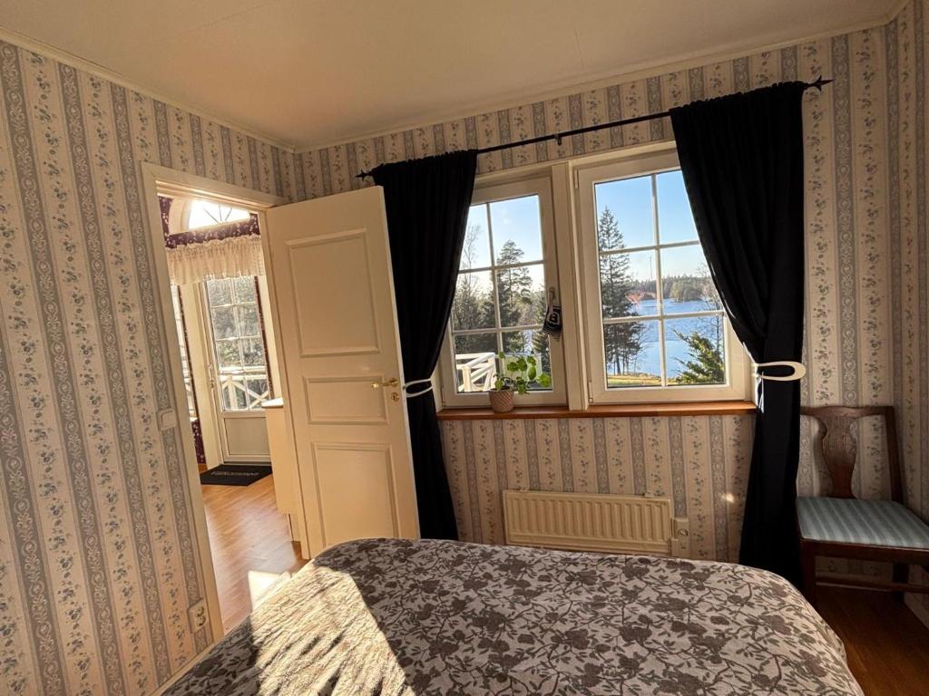 a bedroom with a bed and a window at Stunning lakeside home with sauna surrounded by nature in Sandared