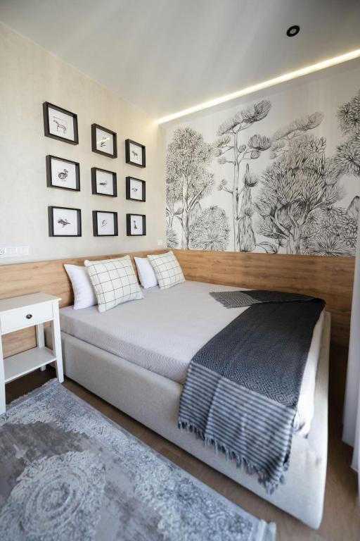 a bedroom with a bed and a wall with pictures at MYFREEDOM апартаменти в ЖК Нова Англія, Британський квартал in Kyiv