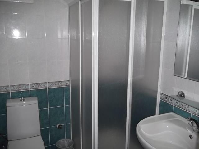 a bathroom with a shower and a toilet and a sink at Antik Ridvan Hotel in Çeşme