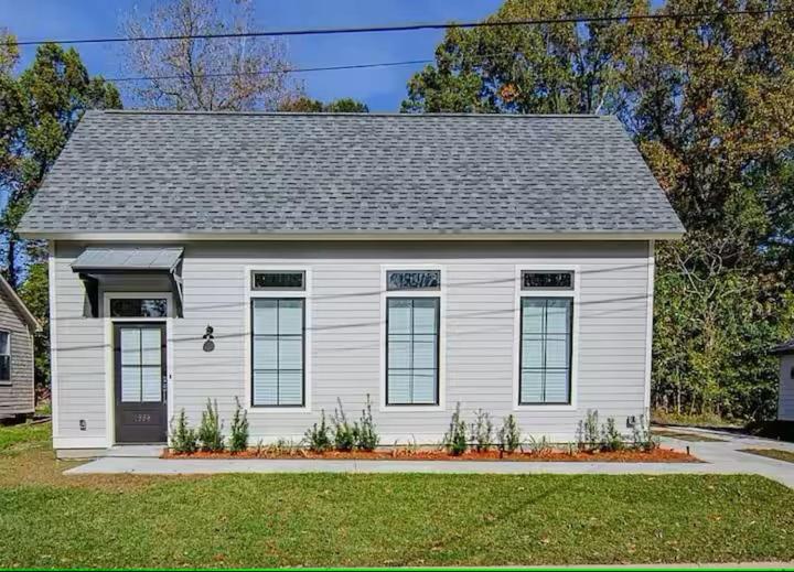 a small white house with a gray roof at The Blue Heron Haven in Baton Rouge