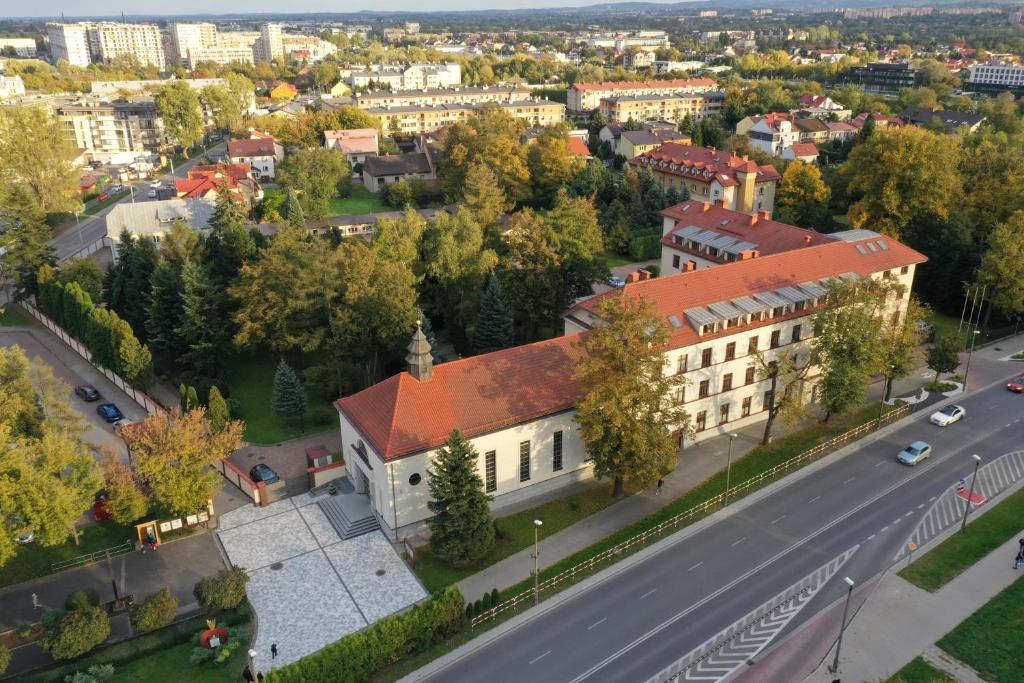 an old building with a red roof on a city street at Domus Mater Hotel in Kraków