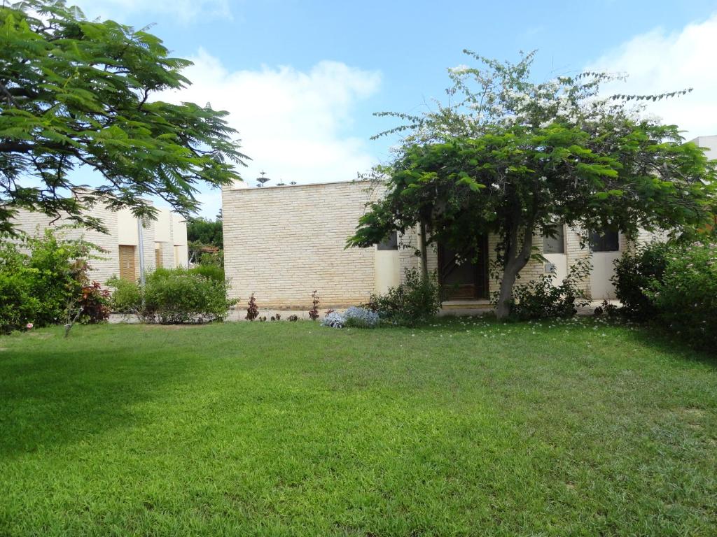 a house with a green yard in front of it at Villa at Karawan Resort in Al Ḩammām