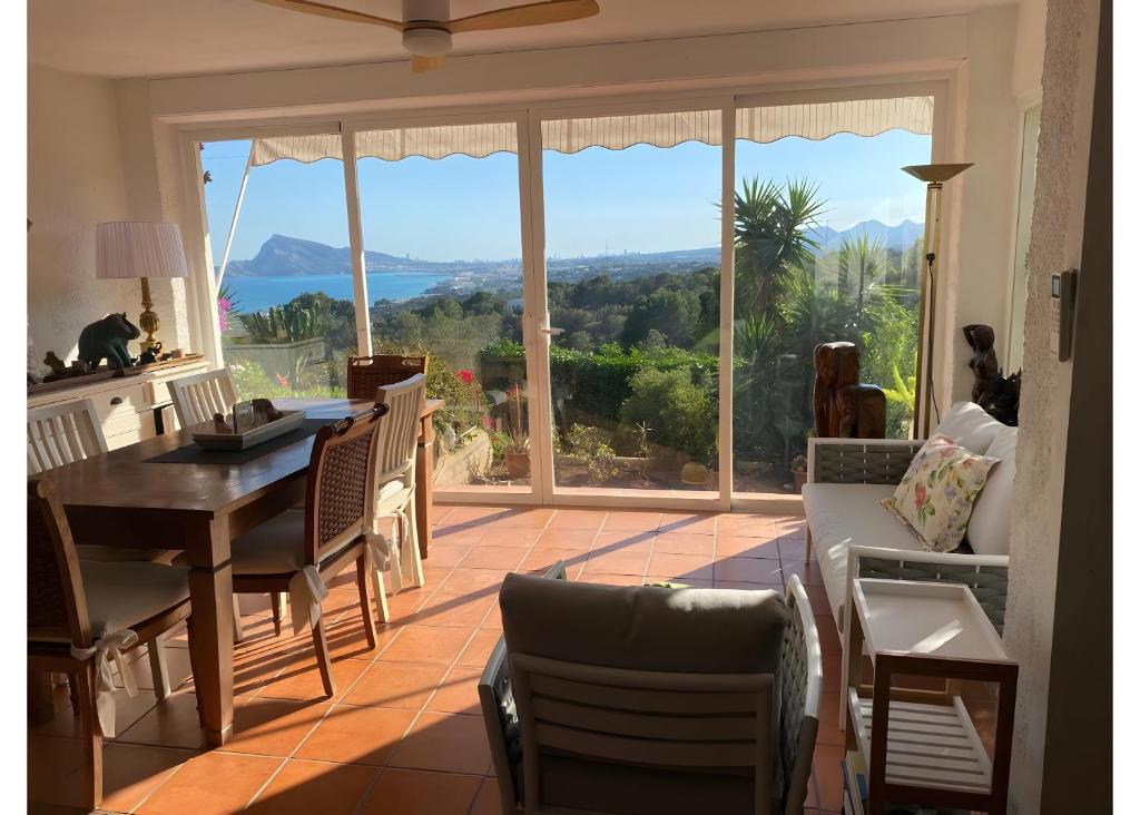 a living room with a table and chairs and a large window at Oceanview House Altea Hills in Altea la Vieja