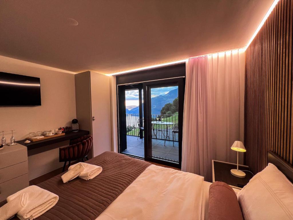 una habitación de hotel con una cama y una ventana grande en Villa Tauris, en Emmetten