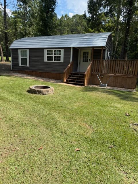 a small house in a yard with a yard at Trails , Tails , and Scales Cabin 2 in Burkeville