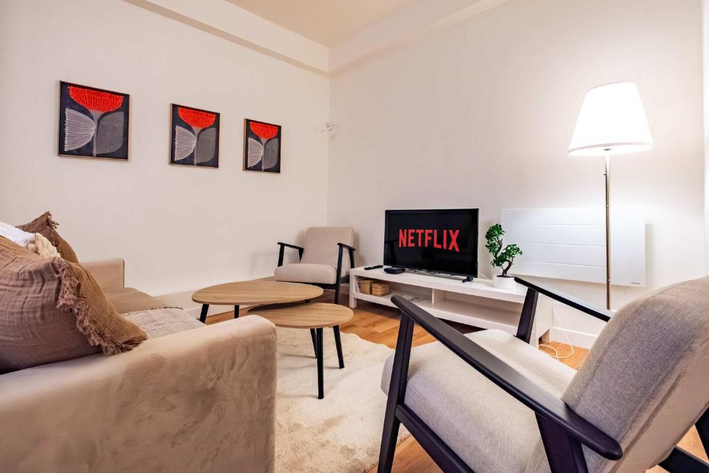 Una sala de estar con un sofá y un televisor. en 6 Guests Flat in heart of Paris - Pompidou, en París