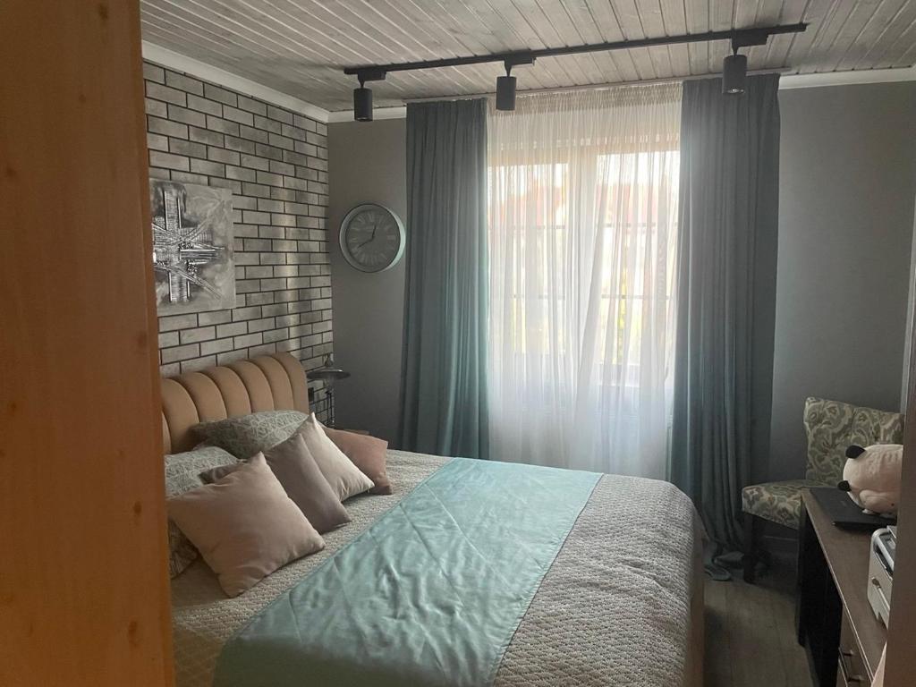 a bedroom with a large bed and a window at Номера in Dobrovelychkivka