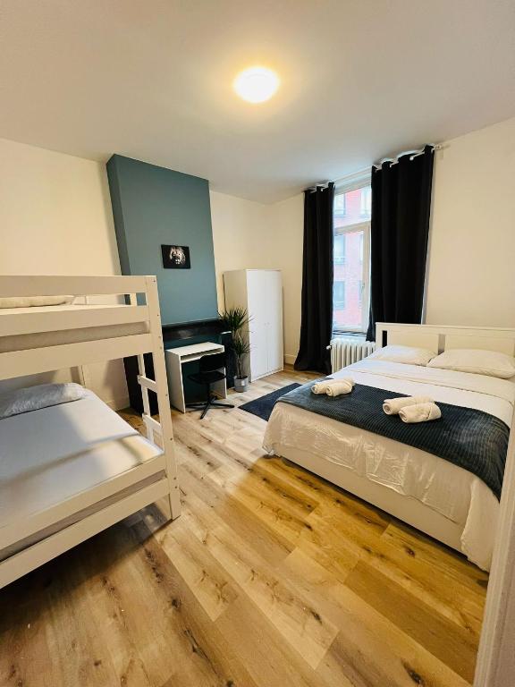 a bedroom with two bunk beds and a desk at Albergue Bosquet in Brussels