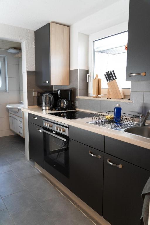 a kitchen with a black stove and a sink at Studio 17 FeWo Schwaigern in Schwaigern