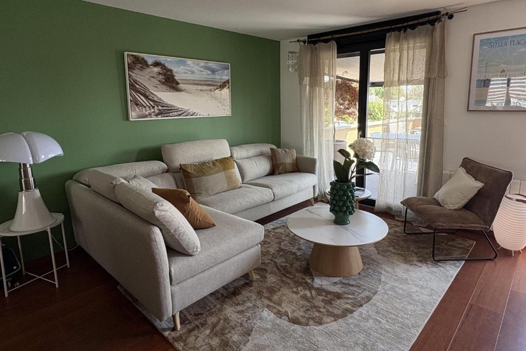 a living room with a couch and a table at New apartment with terrace in the center in Stella-Plage