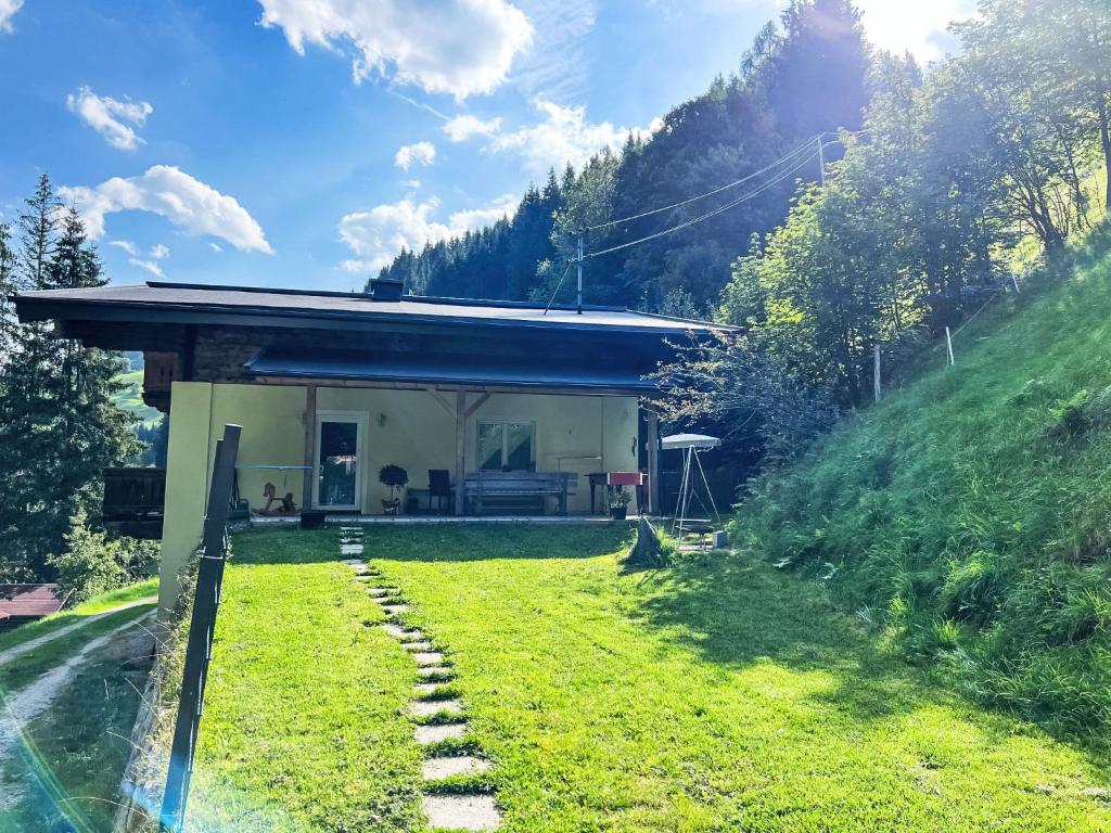 a house on a hill with a grass yard at Apartment Benjamin by Interhome in Hollersbach im Pinzgau