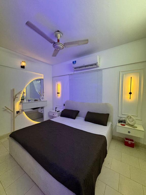 1 dormitorio con 1 cama grande con iluminación púrpura en Luxury beach studio, en Karachi