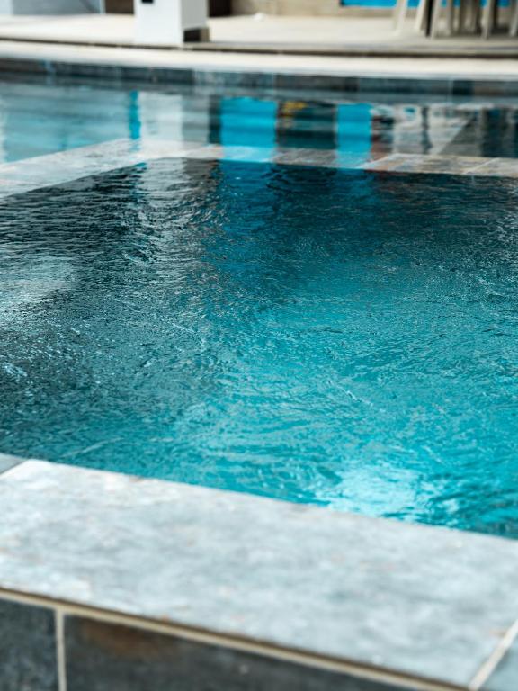 サン・フェリペ・デ・プエルト・プラタにあるOcean Winds Hotelの建物内の青い水のプール