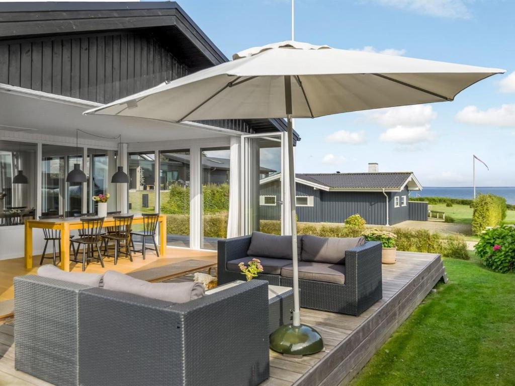 an umbrella on the deck of a house at Holiday Home Hubertina - 75m from the sea by Interhome in Hejlsminde