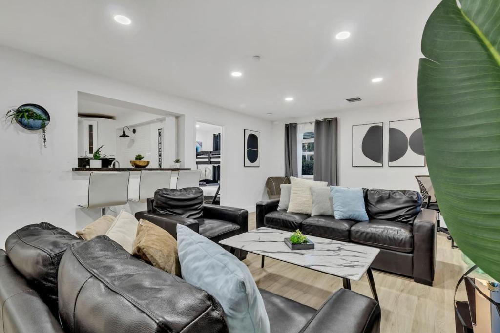 a living room with a leather couch and a table at Casa Stella Tropical Pool Beach 8 min in Hollywood