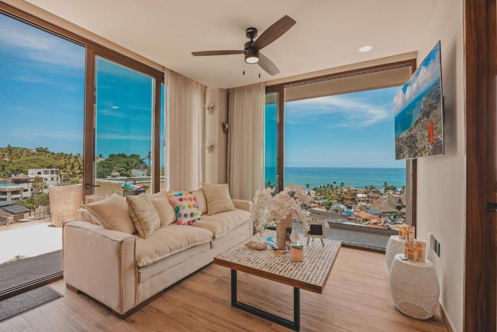 a living room with a couch and a view of the ocean at Dream Sayulita Penthouse in Sayulita