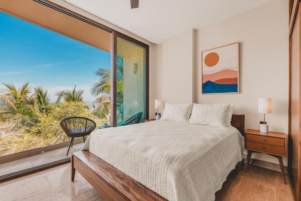 a bedroom with a bed and a large window at Limited Time Offer Luxe 2 BR with Plunge Pool in Sayulita