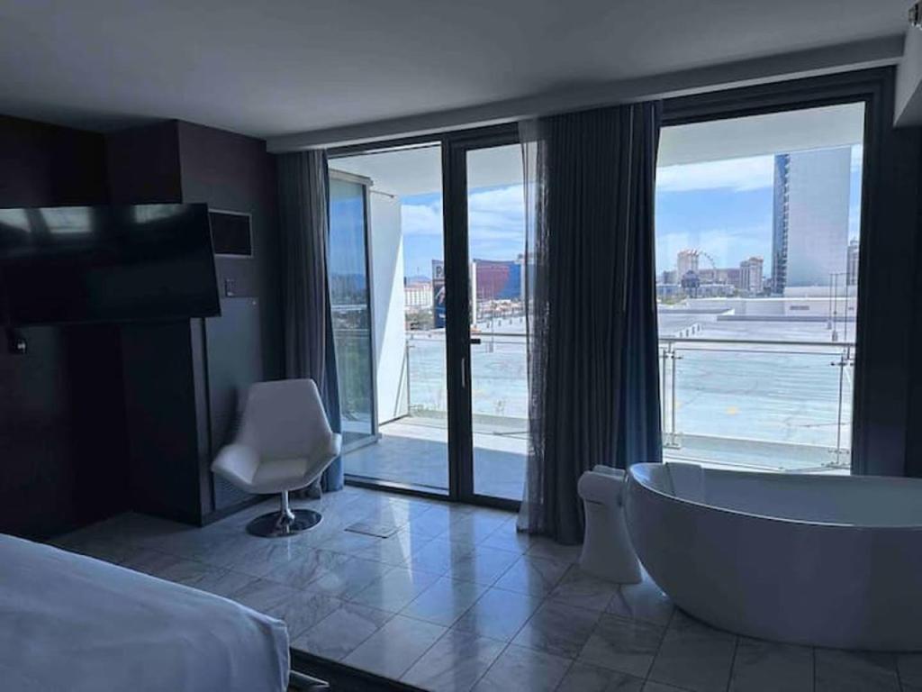 a hotel room with a tub and a large window at Vegas High Rise Condo w 2 Balconies w Resort in Las Vegas