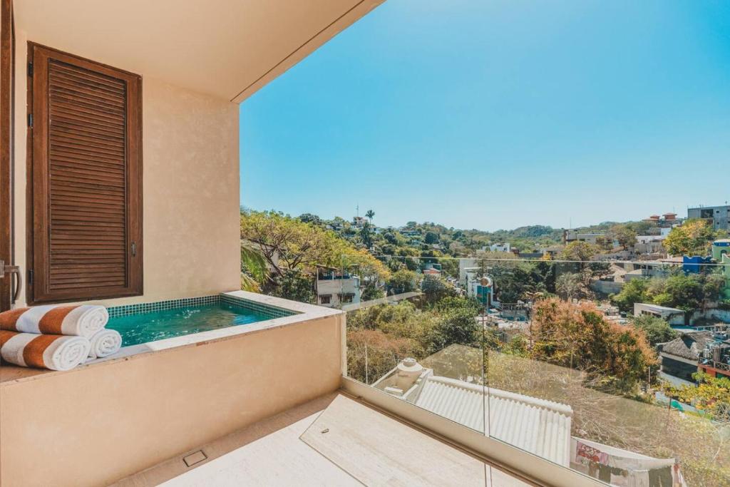 a balcony with a pool and a view of a city at Your Sayulita Getaway in Sayulita