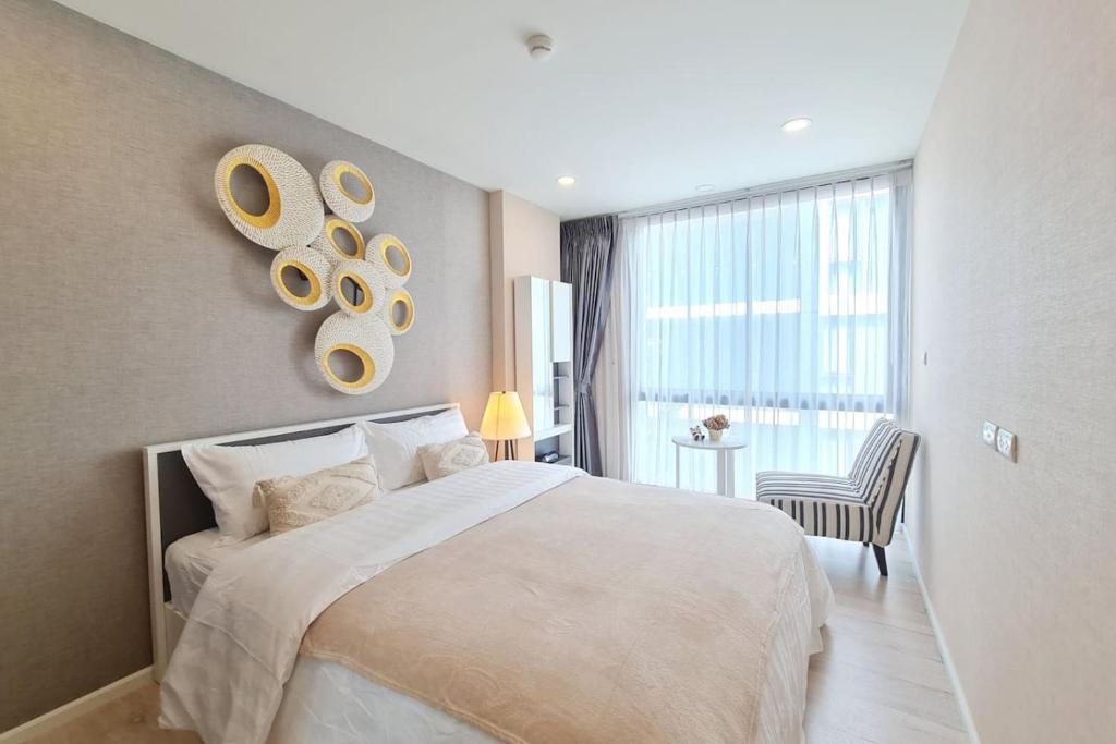 a bedroom with a large bed and a chair at Cozy Condo Perfect Location In Nimmanhemin Maya in Chiang Mai