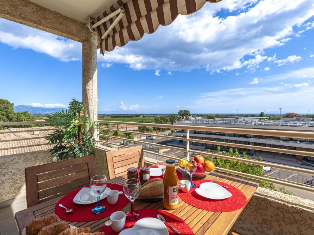 a table with food and wine glasses on a balcony at Apartment Albarella by Interhome in LʼArena