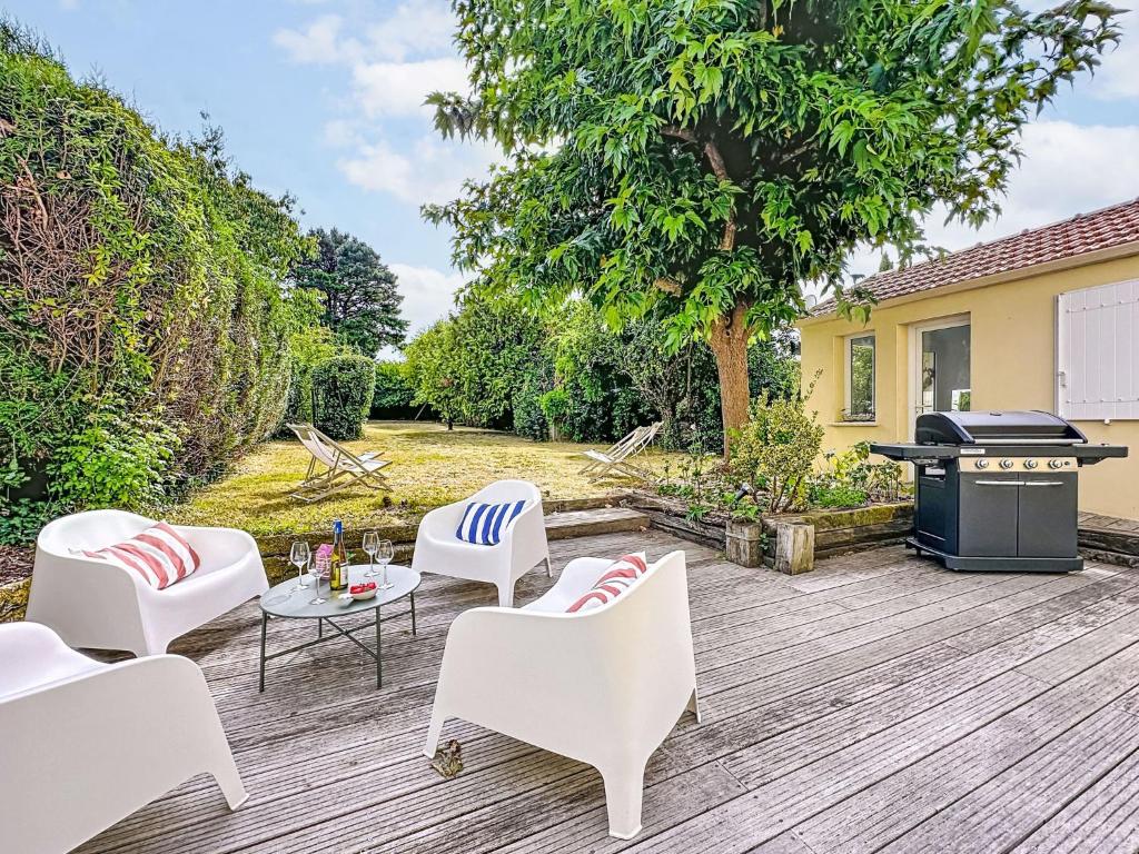 eine Terrasse mit weißen Stühlen und einem Grill in der Unterkunft Holiday Home La Nero by Interhome in Pornic