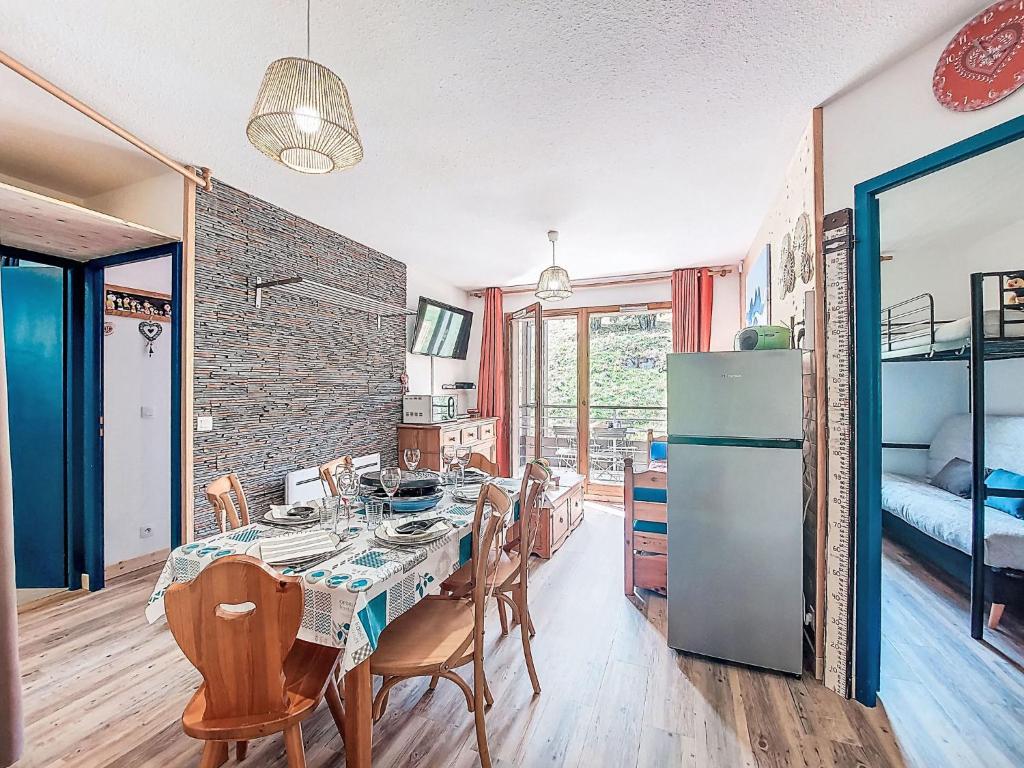 eine Küche und ein Esszimmer mit Tisch und Stühlen in der Unterkunft Apartment Les Pistes-21 by Interhome in Le Corbier