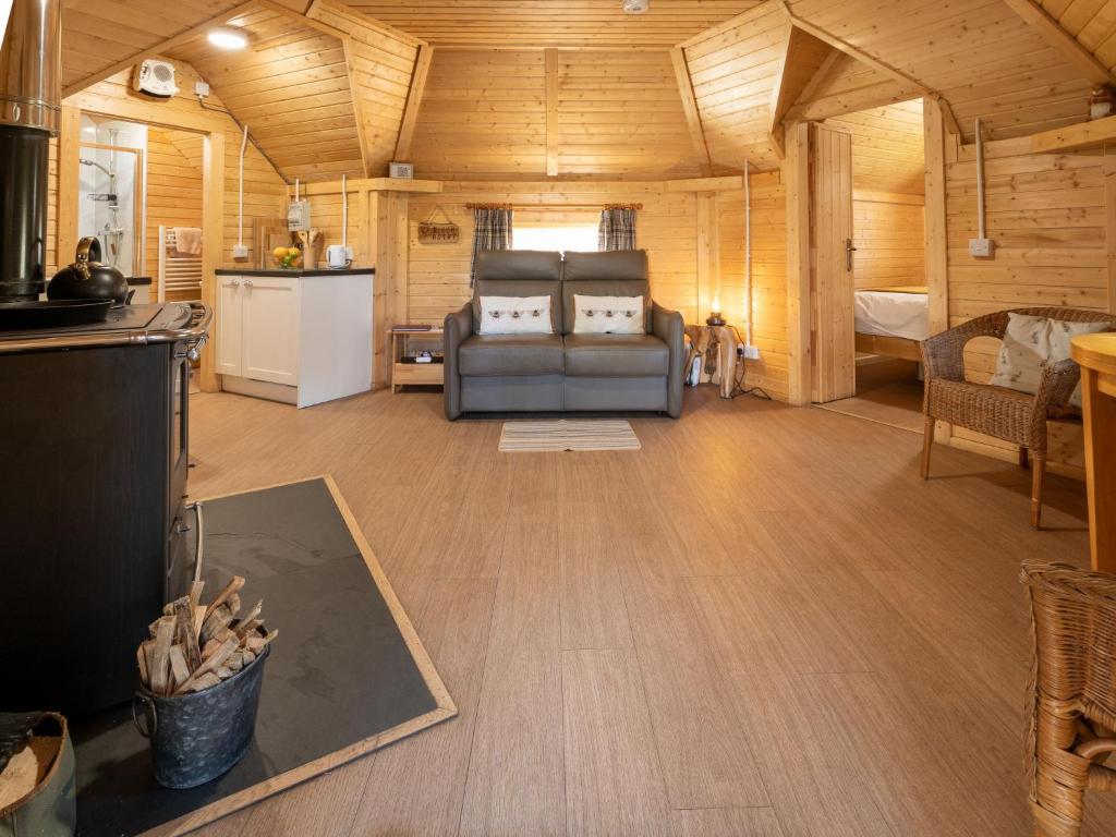 a living room with a couch and a kitchen at Chalet Birch Bothy by Interhome in Coldstone