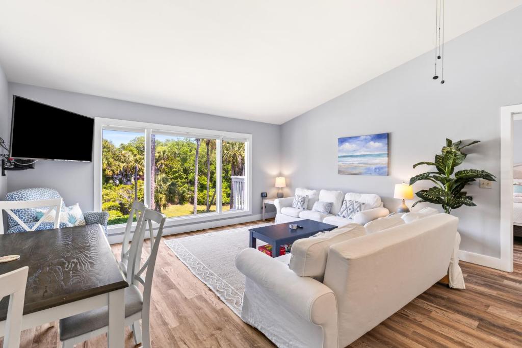 ein Wohnzimmer mit einer weißen Couch und einem Tisch in der Unterkunft Lagoon Villa 6 - 5 Min Walk to Beach! Top Floor! in Isle of Palms
