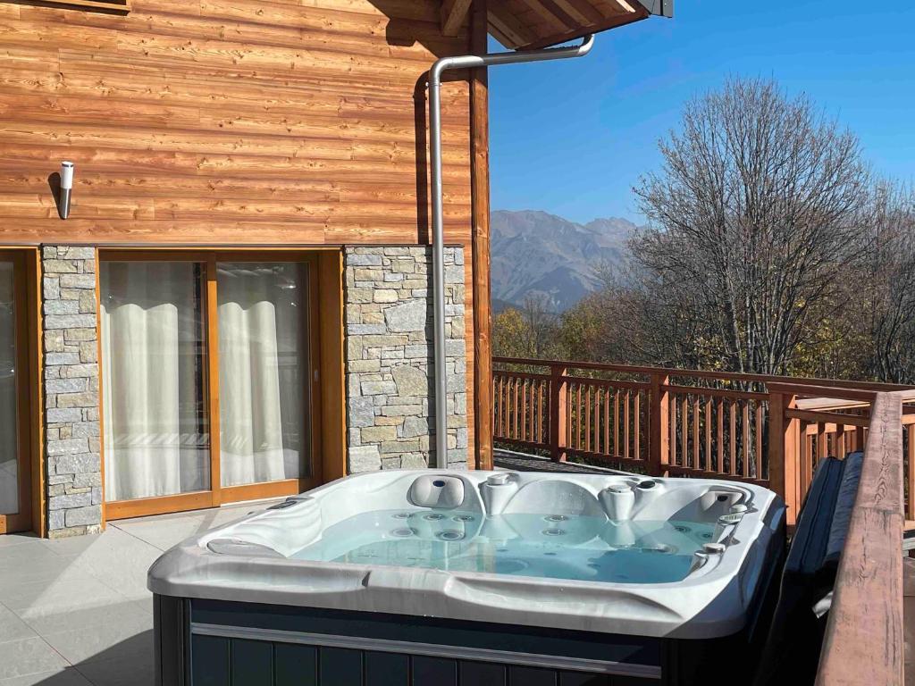 a hot tub on the deck of a house at Germain Ski Lodge in La Toussuire