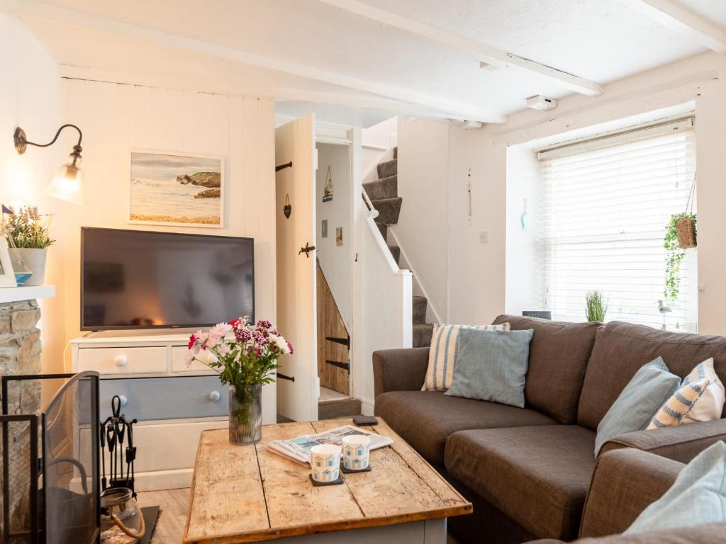 a living room with a couch and a table at Holiday Home Mermaid Cottage by Interhome in Mevagissey