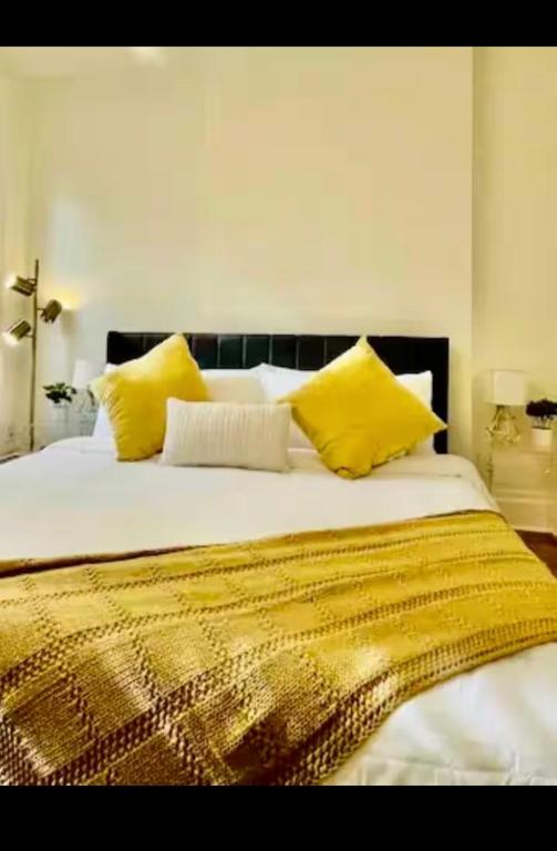 Un dormitorio con una cama grande con almohadas amarillas. en Very comfortable 2 bdrm Condo in French Quarters, en Nueva Orleans