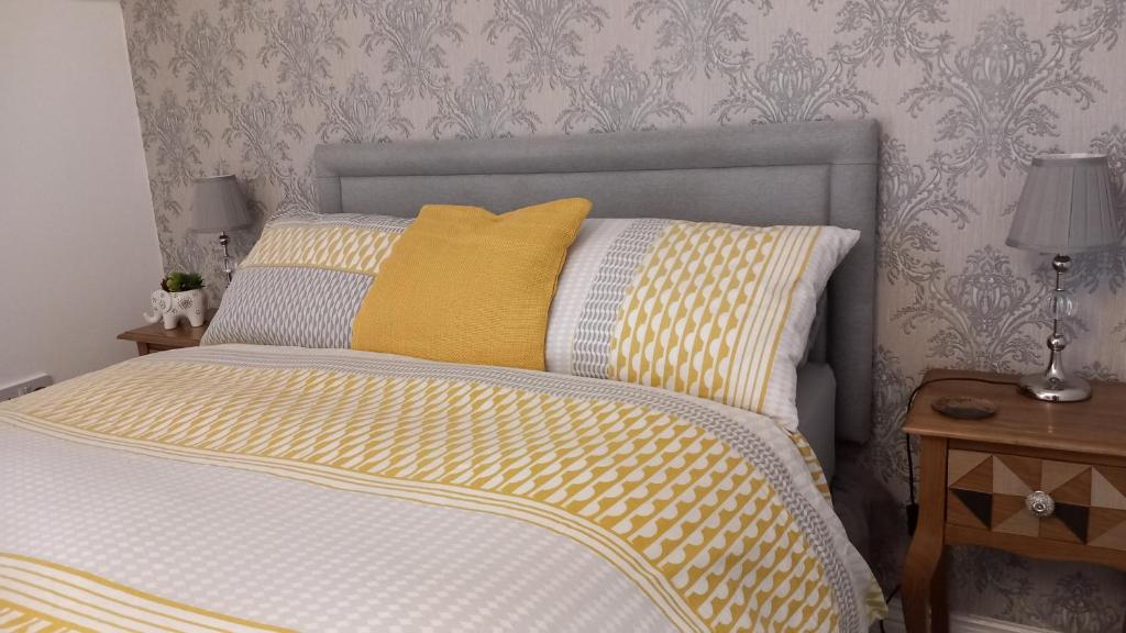 a bedroom with a bed with a yellow pillow at No. 5 in Hartlepool