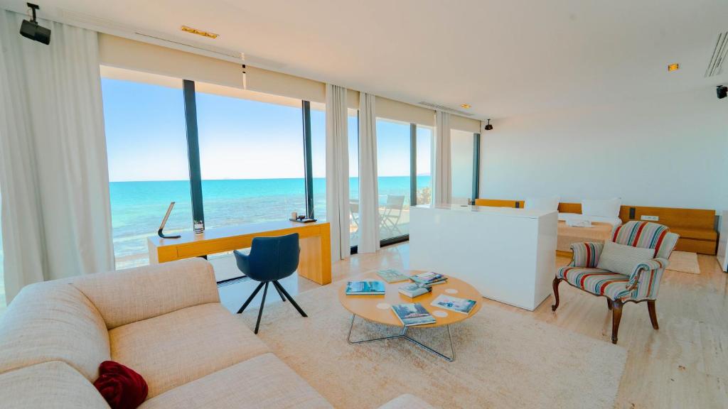 a living room with a couch and chairs and the ocean at Villa AMAYA Grand Luxe face a la mer in Douar el Hafey