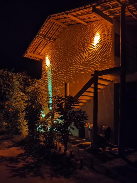 a building with a light on the side of it at night at Kitnets ESPELHO a 160 metros da Praia do Espelho in Praia do Espelho