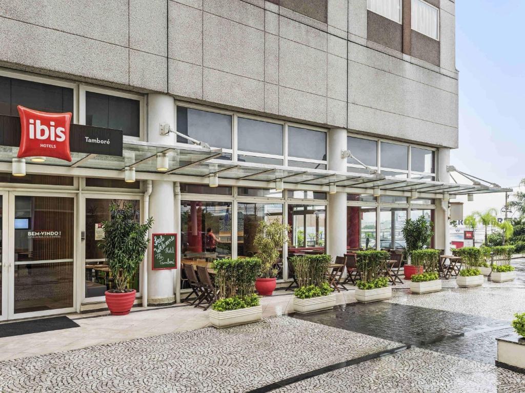 a building with potted plants in front of it at ibis Tambore in Barueri