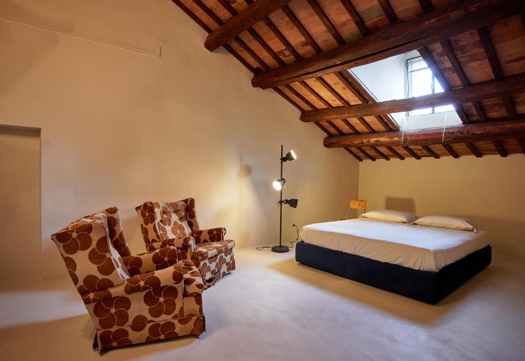 un dormitorio con una cama y una silla en Appartamento Rebel House, en Pergola