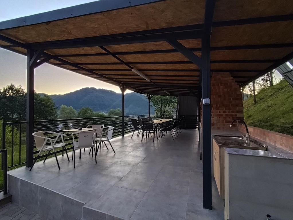 a patio with tables and chairs with a view at CasaNatur in Leordina