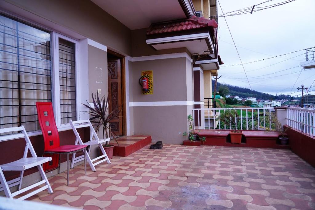 - un balcon d'une maison avec deux chaises et une table dans l'établissement KP Holidays తెలుగు Cottage, à Ooty