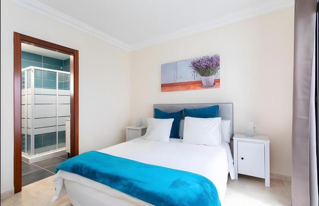 El GuinchoにあるApartamento Rolycar 102のベッドと窓のある白い寝室