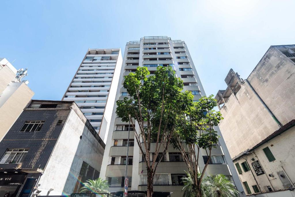 un edificio blanco alto con un árbol delante de él en Center Tower, en São Paulo