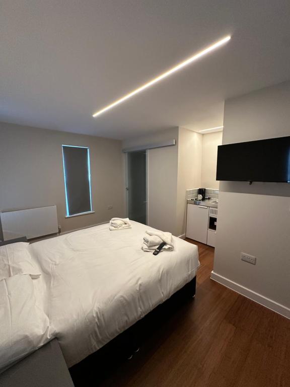 Un dormitorio con una cama grande y una cocina. en Buckingham Annexe, en High Wycombe