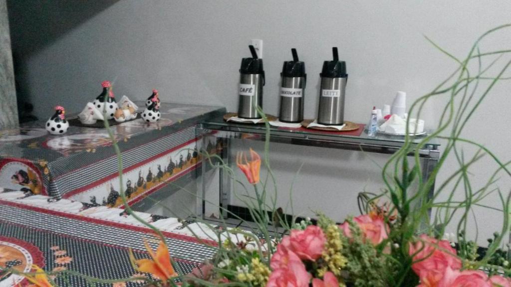 a table with three bottles on it with flowers at Pousada Hotel Santa Helena in Juazeiro do Norte